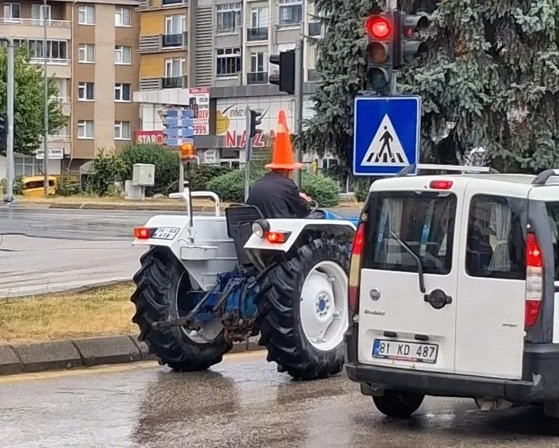 Bolu’da sağanak sırasında yağmurdan korunmak isteyen traktör sürücüsü, başına trafik