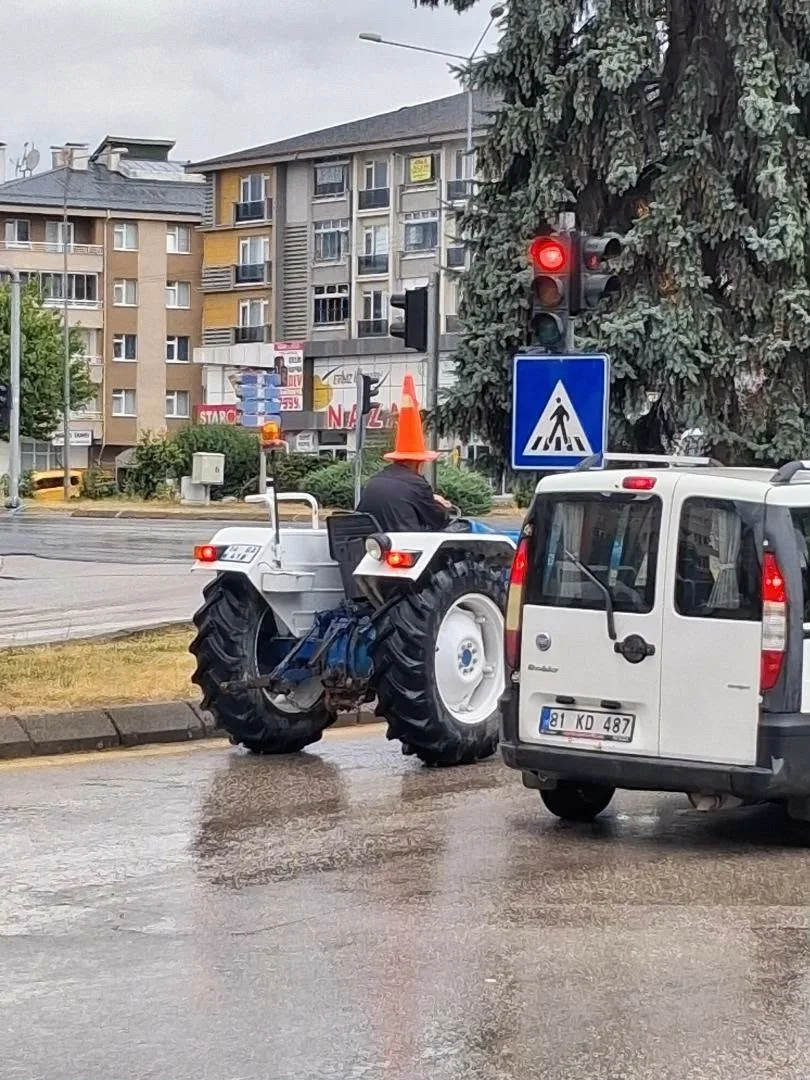 Bolu’da sağanak sırasında yağmurdan korunmak isteyen traktör sürücüsü, başına trafik